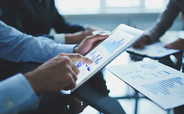 Data analysis on a tablet in a modern business meeting for fintech solutions.