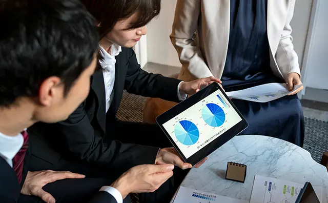 Data analysis meeting: Colleagues collaborate on fintech strategies using a tablet.