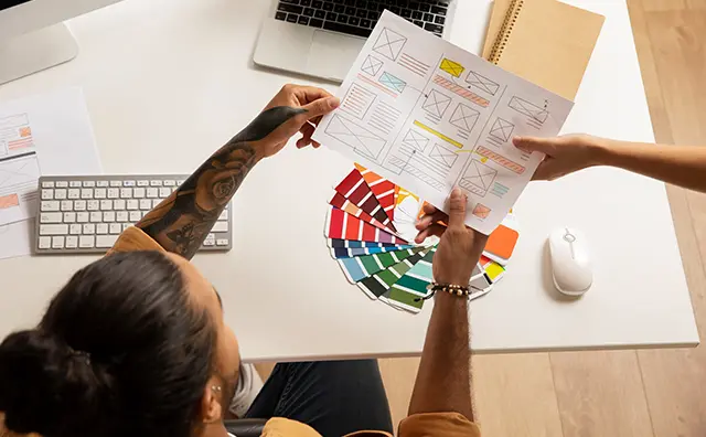 Design workspace collaboration showing UI sketches and digital design tools.