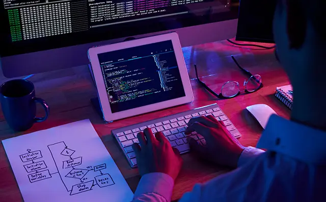 Coding setup shows a programmer working on digital infrastructure solutions.